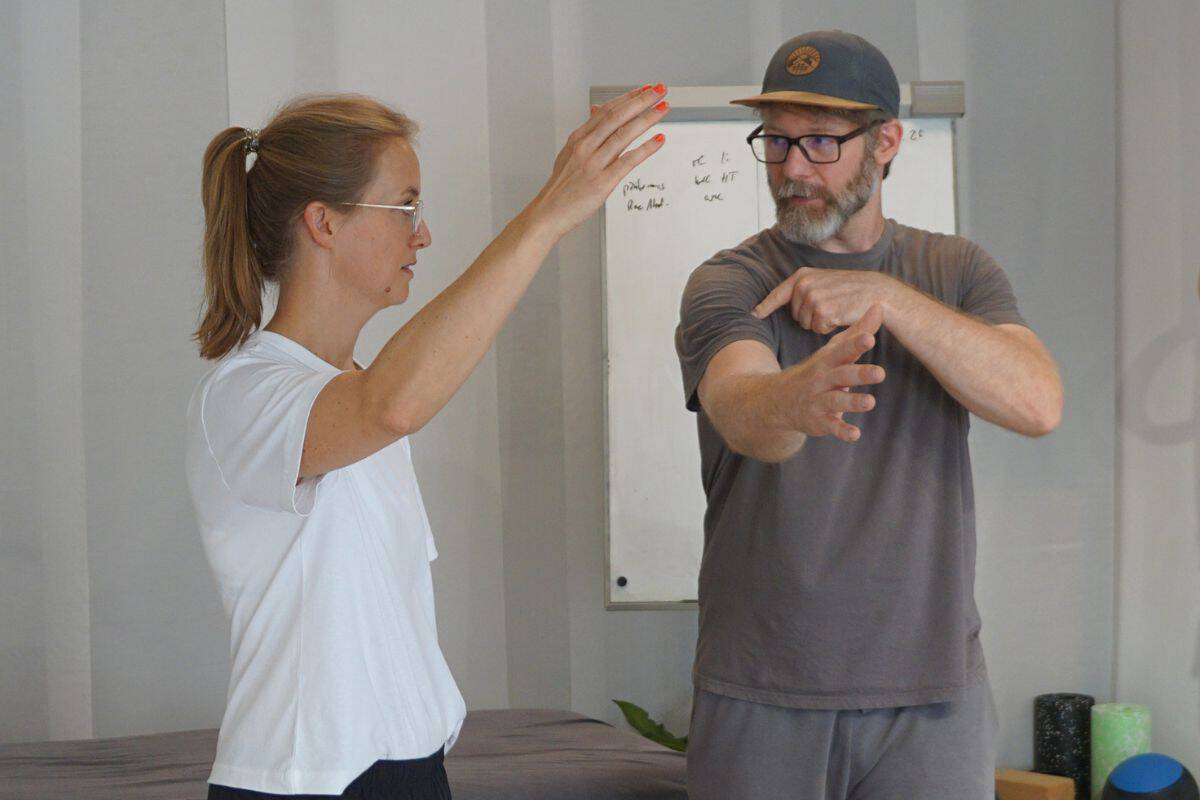 Tobi Müller erklärt einer Patientin die Armbewegung – Bewegungstherapie Sporttherapie Gröbenzell