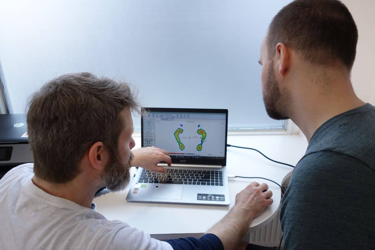 Tobi Müller erklärt Fußdruckanalyse am Laptop – Ursachensuche bei chronischen Schmerzen Gröbenzell