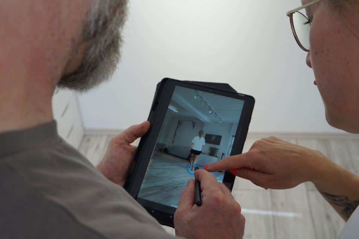 Ganganalyse auf dem Tablet – Tobi Müller zeigt einer Patientin die Auswertung, Sporttherapie Gröbenzell